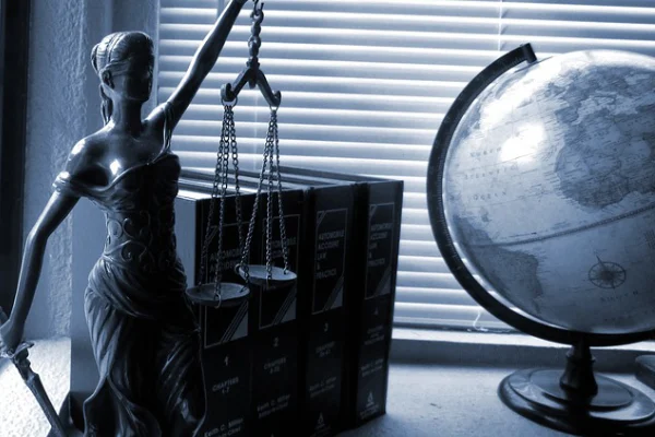 statue with weights on desk with a globe